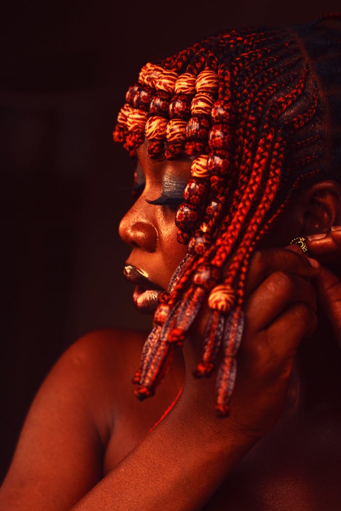 Striking portrait of a woman with intricate, colorful braided hairstyle.