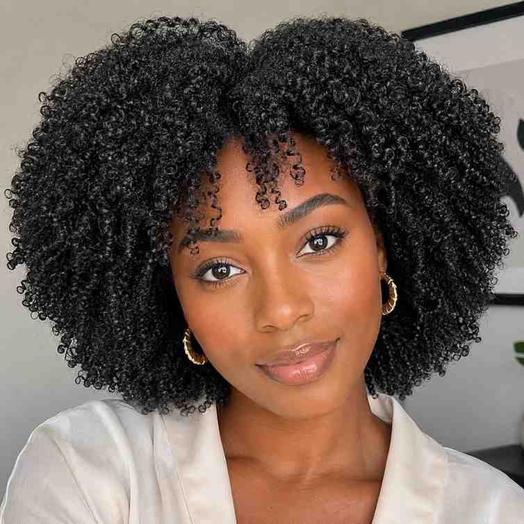 Natural Hairstyles for Heart-Shaped Faces (4C Hair Edition) Black woman with 4C wash and go natural hair, heart-shaped face, coils defined and voluminous